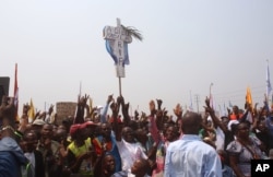 FILE - Supporters of Congo opposition leader Etienne Tshisekedi hold up a cross that symbolizes no third term for DRC President Joseph Kabila, during a political rally in Kinshasa, DRC, July 31, 2016.