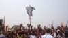 FILE - Supporters of Congo opposition leader Etienne Tshisekedi, rear, hold up a cross that symbolizes no third term for DRC President Joseph Kabila, during a political rally in Kinshasa, DRC, July 31, 2016.