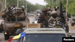 FILE - Chadian soldiers drive in retaken town of Damasak, Nigeria, March 18, 2015.