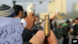 An Egyptian protester shows a spent cartridge casing during a demonstration at Tahrir Square in Cairo, December 19, 2011.