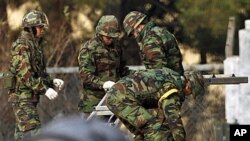 South Korean marines work for restorations of its base damaged by North Korean artillery shelling, at a military base on Yeonpyeong Island November 27, 2010. North Korea fired shells at the island off the peninsula's west coast on Tuesday, killing two civ