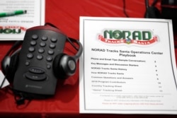 A playbook sits next to a telephone set up in the NORAD Tracks Santa center at Peterson Air Force Base, Monday, Dec. 23, 2019, in Colorado Springs, Colo. More than 1,500 volunteers will handle an estimated 140,000 telephone calls from children and their parents who will be checking on the wherabouts of Santa Claus on Christmas Eve. (AP Photo/David Zalubowski)