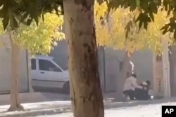 In this still image from video provided by Hengaw Organization for Human Rights, a person tries to help another as gunfire erupts in Javanrud, a Kurdish town in western Iran, Nov. 21, 2022.