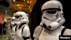 FILE - People dressed as Storm Trooper characters from "Star Wars" await people to purchase toys that are to go on sale at midnight in advance of the film "Star Wars: The Force Awakens" in Times Square in the Manhattan borough of New York.