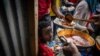 FILE - Elena, 7, center, lines up with other displaced Tigrayans to receive food donated by local residents at a reception center for the internally displaced in Mekelle, in the Tigray region of northern Ethiopia, May 9, 2021.