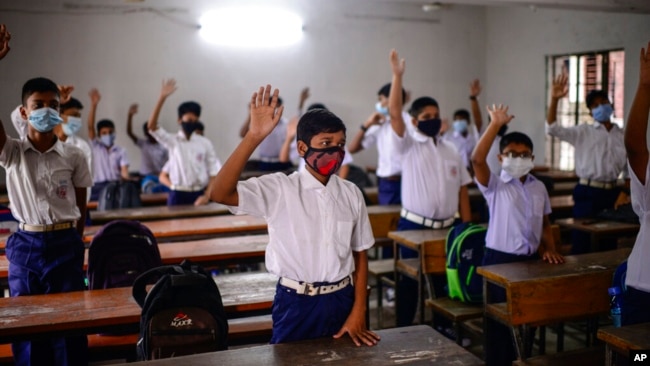 FILE - Students attend a class at the Narinda Government High School as schools reopen after being closed for nearly 18 months due to the coronavirus pandemic in Dhaka, Bangladesh, Sept. 12, 2021. 