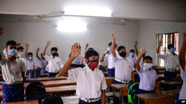 FILE - Students attend a class at the Narinda Government High School as schools reopen after being closed for nearly 18 months due to the coronavirus pandemic in Dhaka, Bangladesh, Sept.12, 2021.