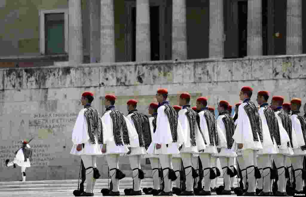 Greek &quot;Evzones&quot; Presidential guards stand at attention during a weekly ceremony at the Monument of the Unknown Soldier in front of the Parliament building in Athens.