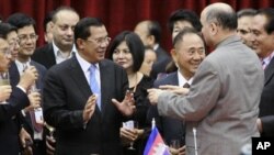 Mushahid Hussain Sayed of Pakistan, secretary-general of Centrist Democrats International Asia Pacific, right, confers with Cambodia's Prime Minister Hun Sen, center left, during a signing ceremony in Cambodia's capital Phnom Penh, Wednesday, Dec. 1, 2010