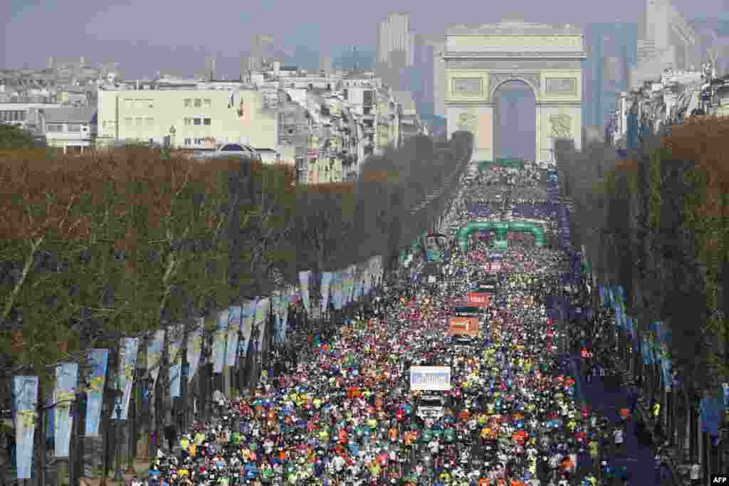 Competitors in the 39th Paris Marathon run down the Champs Elysees in Paris, France.