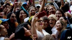 Opposition Congresswoman Adriana Delia, center, poses for a photo with supporters during a protest asking for a referendum against Venezuela's President Nicolas Maduro, outside the National Electoral Council, in Caracas, Venezuela, July 19, 2016.