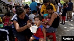 Người dân nhận thức ăn miễn phí do cá cư dân và các tình nguyện viên cung cấp tại một khu vực có thu nhập thấp của Caracas, Venezuela, hôm 17/9/2016. Hội Chữ thập đỏ và LHQ sẽ cung cấp thêm hoạt động cứu trợ tới đất nước này.