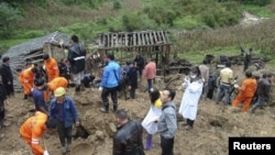 Rescuers search for victims after a landslide engulfed a building of a primary school at Zhenhe village of Yiliang county, Yunnan province, China, October 4, 2012. 