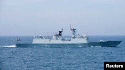 A Chinese naval Z-9 helicopter prepares to land aboard the PeopleÕs Liberation Army (Navy) frigate CNS Huangshan (FFG-570) as the ship conducts a series of maneuvers and exchanges with the Arleigh Burke-class guided-missile destroyer USS Sterett (DDG 104)