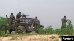 FILE - Afghan soldiers fire a machine gun during a gun battle with Taliban forces in Afghanistan's northern Baghlan province, April 15, 2010.