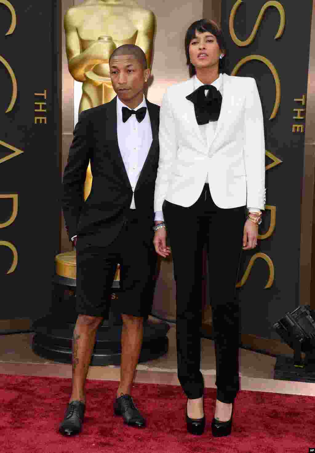 Pharrell Williams, left, and Helen Lasichanh arrive at the Oscars on March 2, 2014, at the Dolby Theatre in Los Angeles.