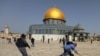 Un camarógrafo cae el suelo perseguido por un policía isralí durante enfrentamientos en el complejo de la mezquita de al-Aqsa en Jerusalén el 10 de mayo de 2021.