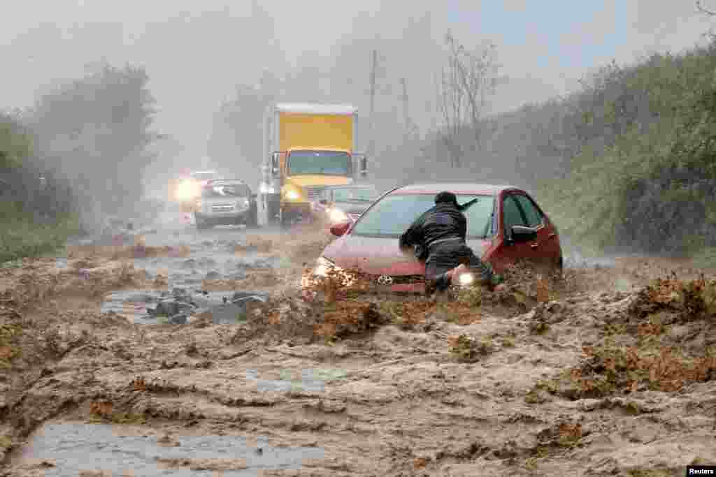 A local resident helps free a car that became stranded in a stretch of flooding road as Tropical Storm Helene strikes, on the outskirts of Boone, North Carolina, Sept. 27, 2024.