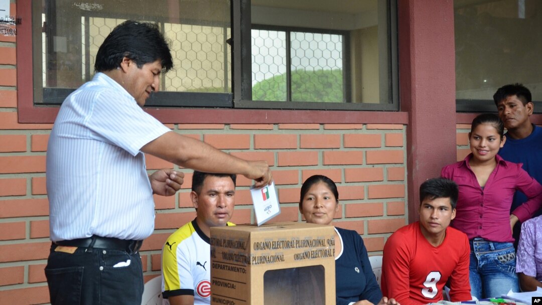 Bolivia's President Evo Morales, left, casts his ballot at a polling station in Villa 14 de Septiembre, in the Chapare region, Bolivia, Sunday, Feb. 21, 2016.