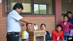 Bolivia's President Evo Morales, left, casts his ballot at a polling station in Villa 14 de Septiembre, in the Chapare region, Bolivia, Sunday, Feb. 21, 2016.