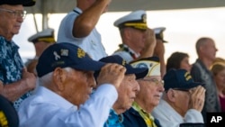 Sobrevivientes de Pearl Harbor Harry Chandler (desde la izquierda), Ken Stevens, Herb Elfring e Ira "Ike" Schab saludan mientras se toca el himno nacional durante la 82.ª ceremonia del Día del Recuerdo de Pearl Harbor, 7 de diciembre de 2023, en Pearl Harbor, en Honolulu, Hawái. 