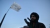 A Taliban fighter stands along a road in Herat on Sept. 19, 2021.