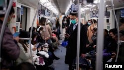 戴着口罩的乘客乘坐上海地铁去上班。（2020年3月9日）