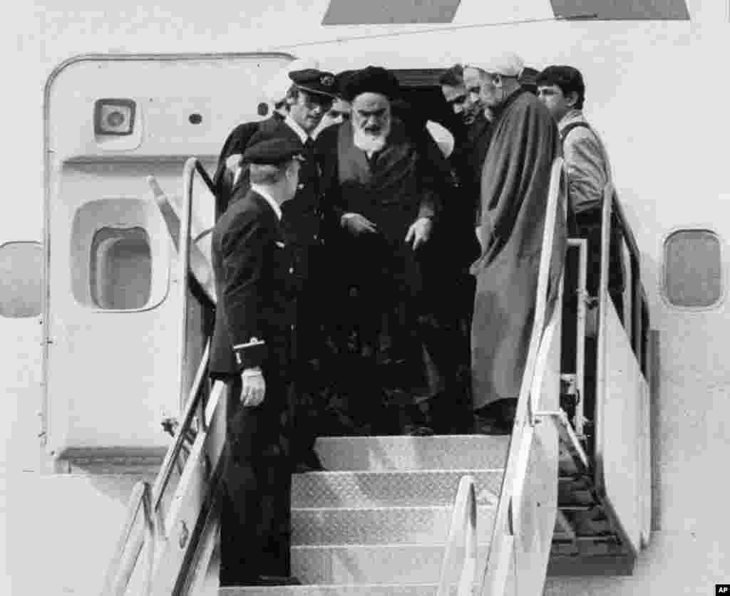 آیت الله روح الله خمینی، رهبر مذهبی ایران در فرودگاه مهرآباد از هواپیما پیاده می شود. وی چهارده سال را در تبعید گذرانده بود &ndash; تهران، ۱۲ بهمن ۱۳۵۷