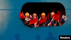 资料照：挥舞着中国和巴拿马国旗的海员在扩大后的巴拿马运河科科利船闸欢迎中国国家主席习近平。(2018年12月3日)