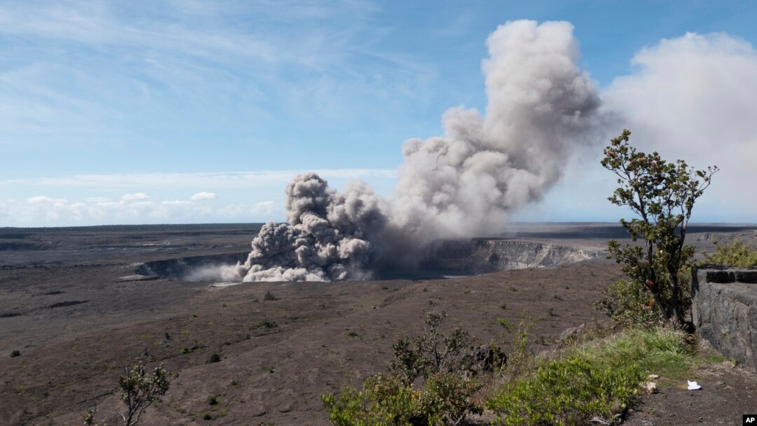 In this May 11, 2018, photo released by the U.S. Geological Survey, a weak ash plume rises from the Overlook Vent in Halema'uma'u crater of the Kilauea volcano on the Big Island of Hawaii. 