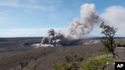 In this May 11, 2018, photo released by the U.S. Geological Survey, a weak ash plume rises from the Overlook Vent in Halema'uma'u crater of the Kilauea volcano on the Big Island of Hawaii. 