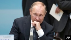 Russian President Vladimir Putin sits before the start of the opening ceremony of the G-20 Summit in Hangzhou in eastern China's Zhejiang province, Sunday, Sept. 4, 2016.