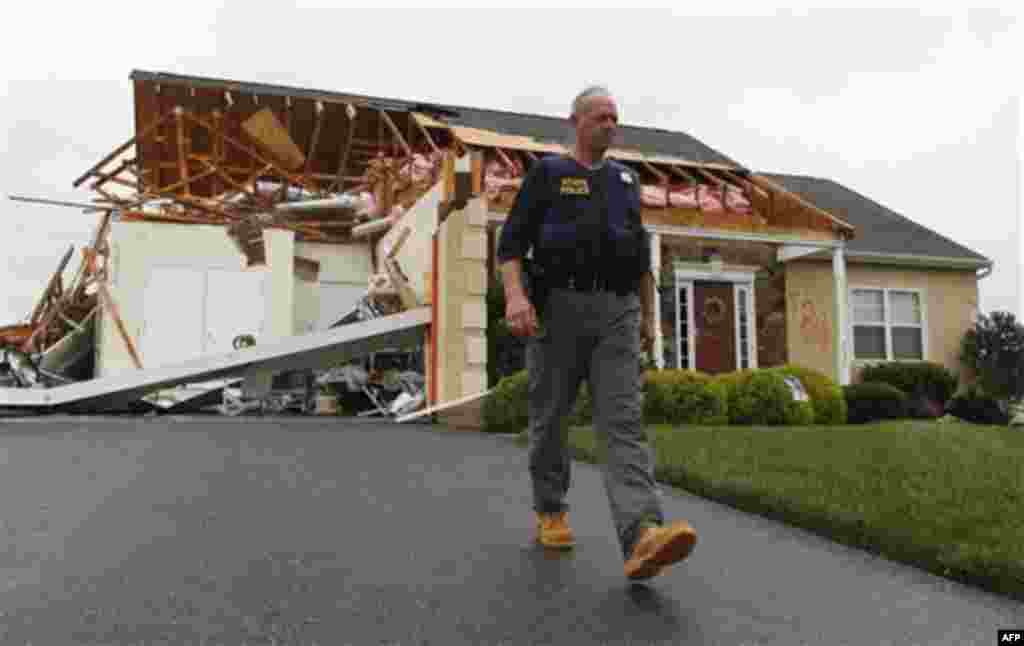 A member of the Delaware State Police walks away from a house that was heavily damaged by a possible tornado in Lewes, Del., Sunday, Aug. 28, 2011, after Hurricane Irene churned along the Delaware coast overnight. From North Carolina to New Jersey, Hurric