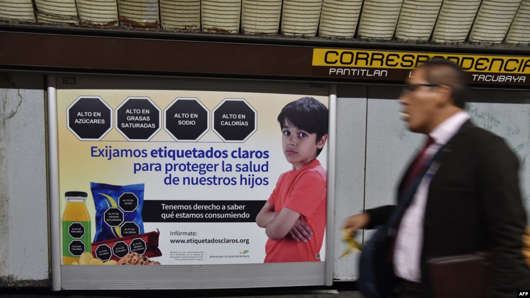 Seorang pria melintas di depan pelabelan makanan di stasiun kereta bawah tanah di Mexico City, 1 Oktober 2019.