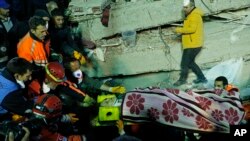 Tim SAR membawa seorang perempuan yang berhasil diselamatkan dari reruntuhan bangunan delapan tingkat yang roboh di Istanbul, Turki, 6 Februari 2019. 