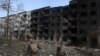 A Ukrainian police officer walks past a destroyed residential building, following artillery and air raids in the village of Ocheretyne, near the town of Avdiivka, in the Donetsk region, April 15, 2024, amid the Russian invasion in Ukraine.