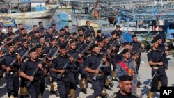 Members of Palestinian Hamas security forces march next to fishing boats during their graduation ceremony at the fisherman's port in Gaza City, in the northern Gaza Strip, Thursday, Dec. 4, 2014. 