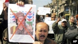 Protesters demonstrate against Libyan Leader Moammar Gadhafi, shown on placard at left, in the Mediterranean port city of Alexandria in Egypt, February 20, 2011