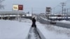 A person clears the snow from the sidewalk in Lowville, New York, Nov. 30, 2024. 