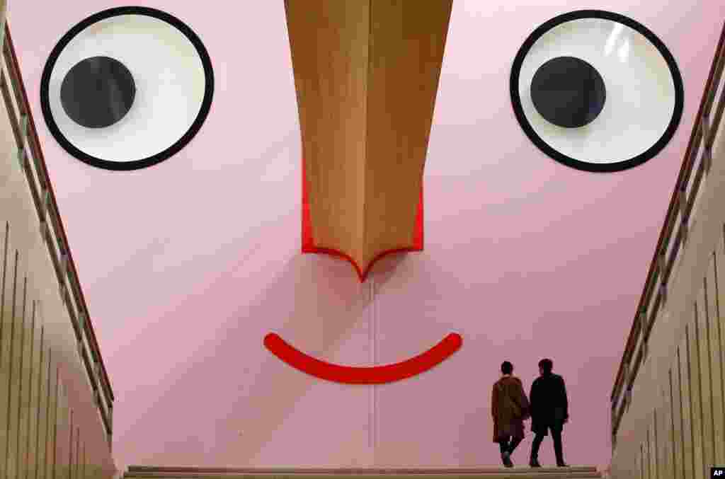 People walk at the entrance of the &quot;Giro Giro Tondo design for children&quot; exhibition, at the Triennale museum, in Milan, Italy.