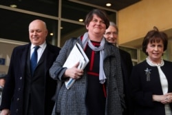 FILE - In this April 11, 2019 file photo, Northern Ireland Democratic Unionist Party leader Arlene Foster, center, speaks to journalists after her meeting with European Union chief Brexit negotiator Michel Barnier at EU headquarters.