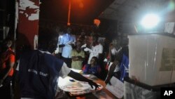 Electoral officials count ballot papers under a lantern light at the end of voting at a polling station in Monrovia, Liberia, Oct. 10, 2017. 