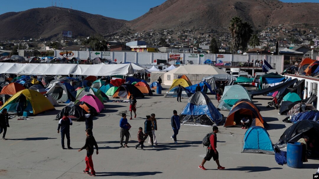 Sekelompok kaum migran berjalan di tempat yang dahulunya menjadi lokasi konser dan sekarang berfungsi sebagai lokasi penampungan di Tijuana, Meksiko, Senin, 3 Desember 2018 (foto: AP Photo/Rebecca Blackwell)