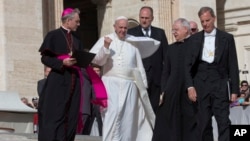 FILE - Pope Francis, flanked by members of his staff, walks during his weekly general audience in St. Peter's Square at the Vatican, Oct. 7, 2015.