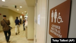 FILE - A sign marks the entrance to a gender neutral restroom at the University of Vermont in Burlington, Vermont. 