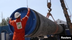 Seorang pekerja menutup pipa di lokasi pembangunan pipa gas Nord Stream 2, dekat kota Kingisepp, wilayah Leningrad, Rusia, 5 Juni 2019. (Foto: Reuters)