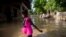 A girl wades towards her flooded home the day after the passing of Tropical Storm Laura in Port-au-Prince, Haiti, Aug. 24, 2020.