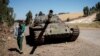 FILE - A young man walks past a destroyed tank near Debre Tabor, Ethiopia, Dec. 6, 2021. Ethiopian and Eritrean forces launched a "massive" joint offensive against the Tigray People's Liberation Front in the northern region of Tigray on Sept. 1, 2022.