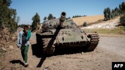 FILE - A young man walks past a destroyed tank near Debre Tabor, Ethiopia, Dec. 6, 2021. Ethiopian and Eritrean forces launched a "massive" joint offensive against the Tigray People's Liberation Front in the northern region of Tigray on Sept. 1, 2022.