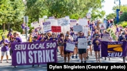 Workers march at American University as a way to pressure the school to work with their union on a contract. (Photo by Dylan Singleton)